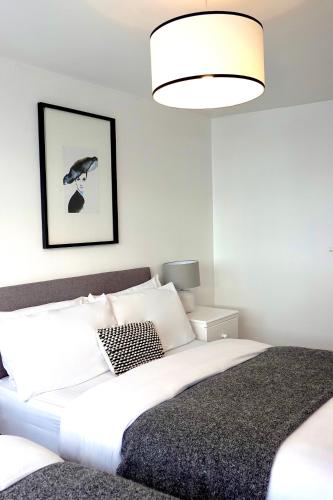 a bedroom with a large white bed with a black blanket at Modern Luxurious Apartment in Birmingham