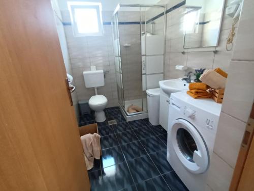 a bathroom with a washing machine and a sink at Studio apartman Paola in Peroj