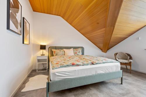 um quarto com uma cama e um tecto em madeira em Wohnung Weitblick em Neu-Anspach