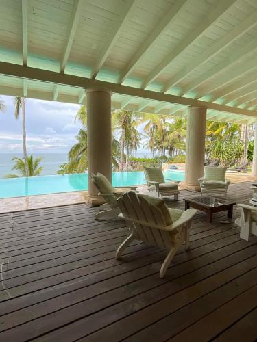 a porch with chairs and a view of the ocean at Los Gorgones Azur Room in Las Galeras