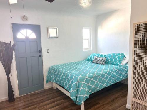 1 dormitorio con 1 cama con edredón azul en Casita San Diego, en San Diego