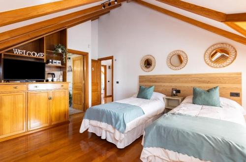a bedroom with two beds and a flat screen tv at CASA LALI in Las Lagunas