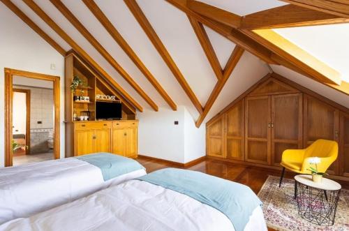 a bedroom with a large bed and a yellow chair at CASA LALI in La Laguna