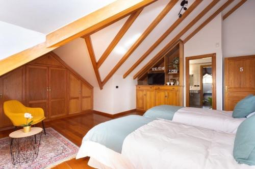 a bedroom with two beds and a yellow chair at CASA LALI in La Laguna
