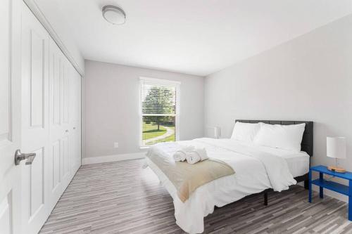 a white bedroom with a large bed and a window at Rochester Hills 2BR/2BA Gem in Rochester Hills