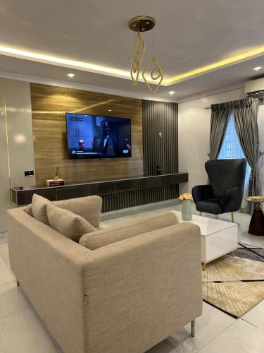 7th Heaven Homes في إيبادان: غرفة معيشة مع أريكة وتلفزيون بشاشة مسطحة
