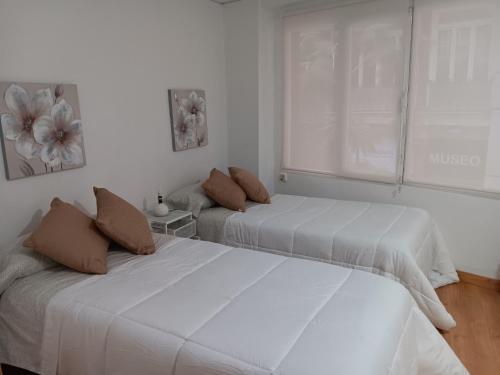 twee bedden in een kamer met witte muren bij Apartment near Plaza Ayuntamiento in the historic center of Valencia in Valencia