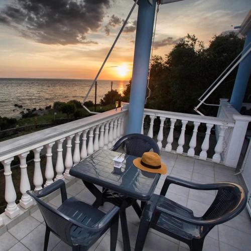 a table and chairs on a balcony with the ocean at VILLA VRACHOS Preveza in Vráchos
