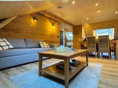 un salon avec un canapé bleu et une table dans l'établissement [Le LODGE], à Cauterets