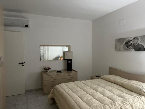 a bedroom with a bed and a dresser and a mirror at Villa Melania in Rossano