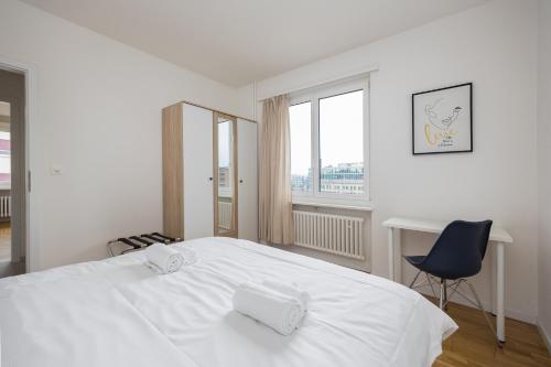 a bedroom with a white bed and a chair and a window at Downtown Dream 3,5BR with Balcony and Style BA42 in Zurich