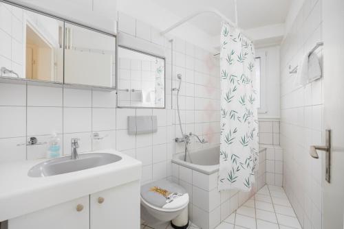 a white bathroom with a sink and a toilet at Downtown Dream 3,5BR with Balcony and Style BA42 in Zürich