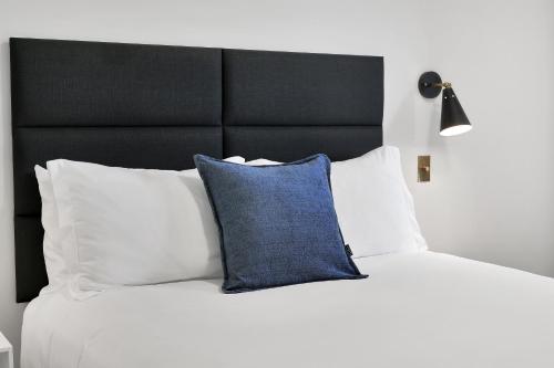 a bed with a black headboard and a blue pillow at Summit Lofts Boutique Hotel in Mount Shasta