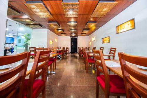 een eetkamer met houten tafels en stoelen bij Atlantic Garden Hotel in Barranquilla
