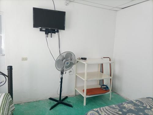 a room with a fan and a television on a wall at Departamento CUARTITO MODESTO DEL PRECIOSO in Martínez de La Torre