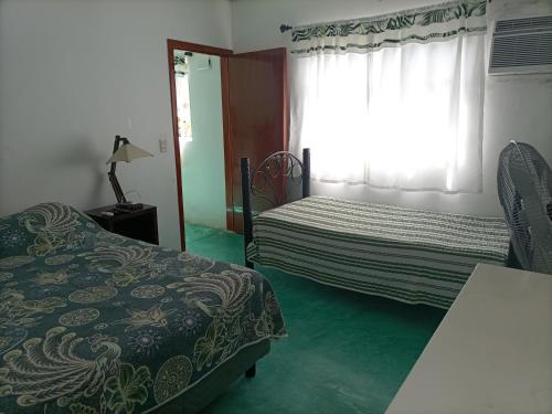 1 dormitorio con 2 camas y ventana en Departamento CUARTITO MODESTO DEL PRECIOSO, en Martínez de La Torre