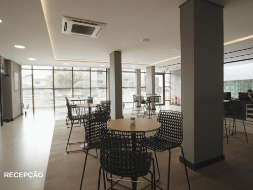 a restaurant with tables and chairs and windows at ApartDamani - Aptos por Temporada no centro in Foz do Iguaçu