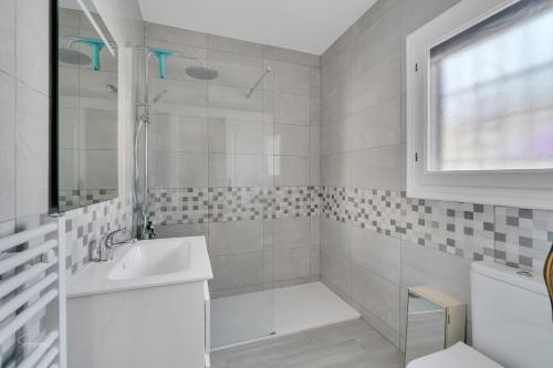 een witte badkamer met een wastafel en een douche bij Casa Nico- by Aldertons in Teulada