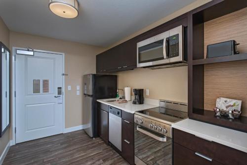 a kitchen with a refrigerator and a microwave at TownePlace Suites by Marriott Columbia in Columbia