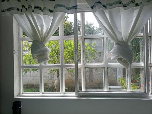 a window with white curtains in a room at Departamento CUARTITO MODESTO DEL PRECIOSO in Martínez de La Torre