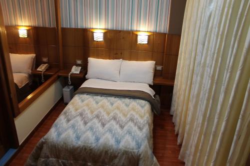 a small room with a bed and a phone at Hotel Venecia in Huánuco