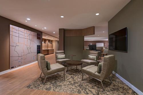 a lobby with a waiting room with chairs and a television at TownePlace Suites by Marriott Columbia in Columbia