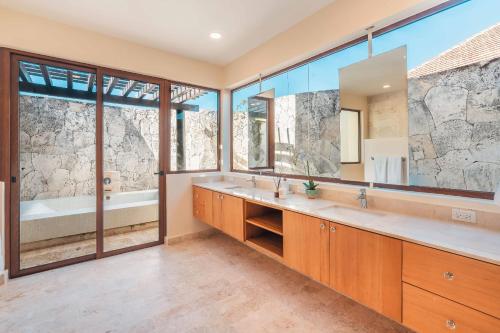 La salle de bains est pourvue de 2 lavabos et d'un grand miroir. dans l'établissement Amazing villa at Green Village ABB, à Punta Cana