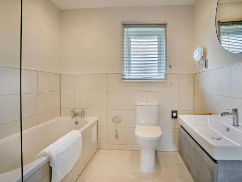 a bathroom with a tub and a toilet and a sink at 3 Bed in Gower 91721 