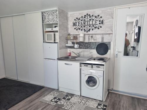 une cuisine avec une machine à laver et un lave-linge dans l'établissement Jolie Maisonnette avec terrasse et jardin, à Roissy-en-Brie