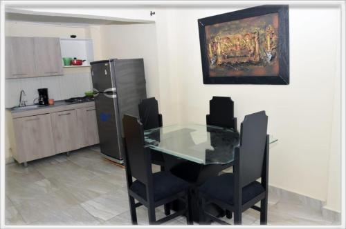 a kitchen with a glass table and chairs and a refrigerator at Familia angel in Dosquebradas