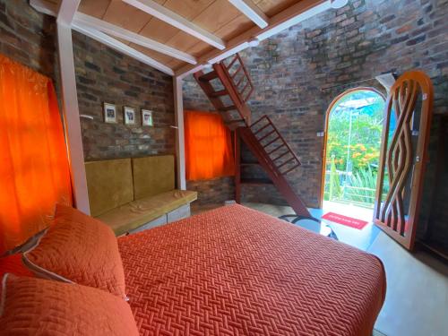 a bedroom with a bed and a brick wall at El Domo Macanal in Macanal