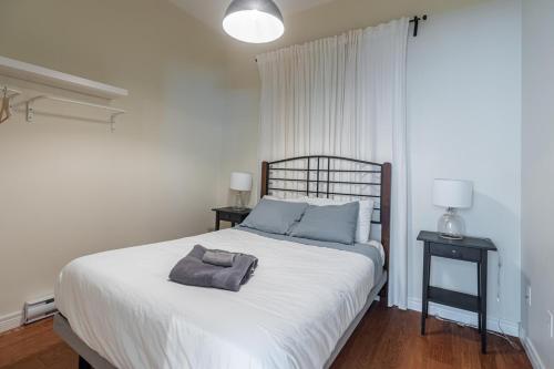 1 dormitorio con 1 cama blanca grande con almohadas azules en Homely Loft #5 with AC, Downtown en Halifax