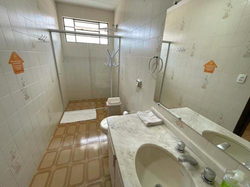 a bathroom with a large sink and a shower at Jardim Botânico House in Curitiba