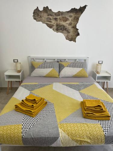 a bedroom with two beds with yellow and gray at I Parienti Ra Zita in Ragusa