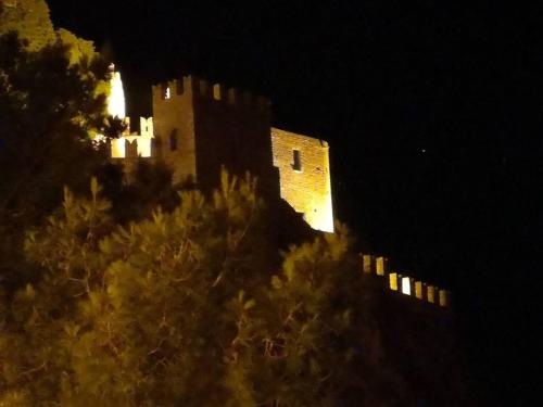 un château assis au sommet d'une colline la nuit dans l'établissement 2 bedrooms house with wifi at Caccamo, à Caccamo