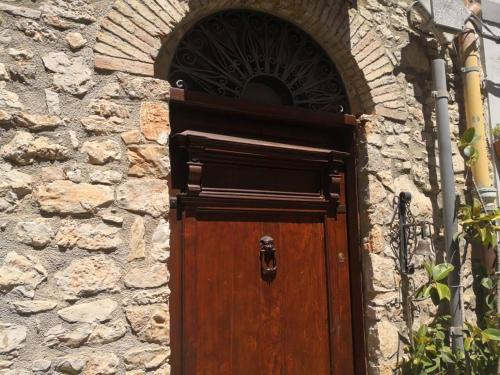 a wooden door in a stone building with a window at 2 bedrooms house with wifi at Caccamo in Caccamo