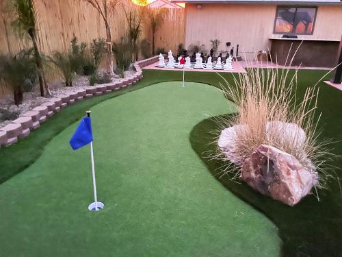a putting green with a blue flag and a golf ball at Buddha Mansion Luxury Resort - 8BR Modern, HotTub, Huge pool, Sauna, BBQ grill, Game Room in Las Vegas