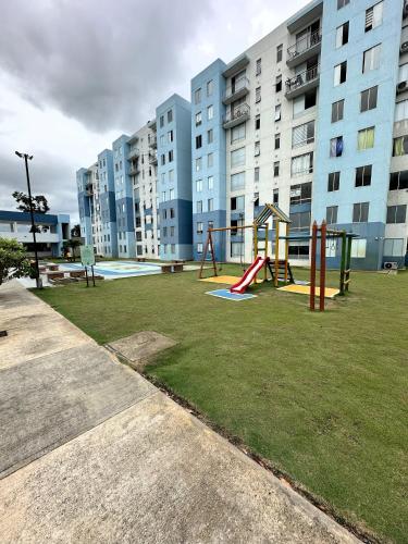 einen Spielplatz vor einem großen Apartmenthaus in der Unterkunft Hermoso Apartamento cerca del centro comercial jardin plaza in Cúcuta