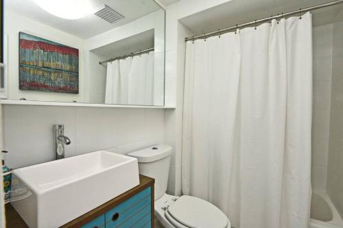 een witte badkamer met een wastafel en een toilet bij Quaint Winter Park East End Home in Orlando