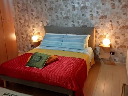 a bedroom with a bed with a red blanket and two lights at One bedroom appartement at Barletta 900 m away from the beach with terrace and wifi in Barletta