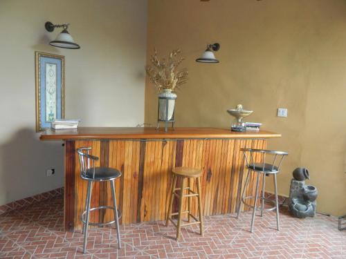 a wooden bar with three stools in a room at Becks Bed & Breakfast in Crooked Tree