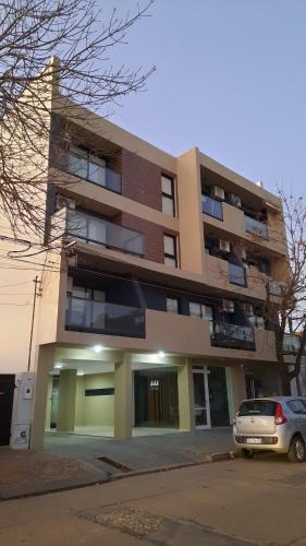 a building with a car parked in front of it at MODERNO MONOAMBIENTE CALIDAD SUPERIOR in Sunchales