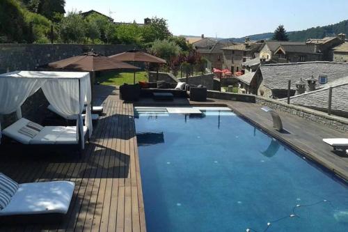una gran piscina con sillas y sombrilla en One bedroom property with private pool sauna and terrace at Boltana, en Boltaña