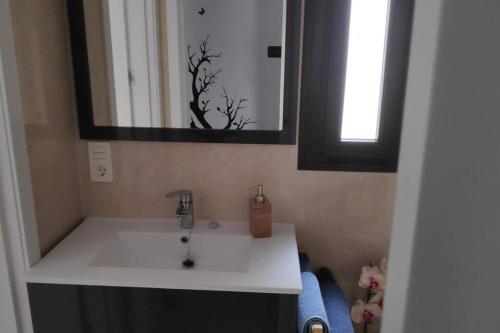 een badkamer met een witte wastafel en een spiegel bij El Palacete de San Juan de los reyes in Toledo