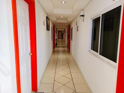 a corridor of an empty hallway with red and white walls at Hotel Puerto México Aeropuerto in Mexico City