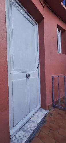 une porte blanche sur le côté du bâtiment dans l'établissement Studio lumineux avec parking proche Monaco, Nice, plage et gare, à Menton