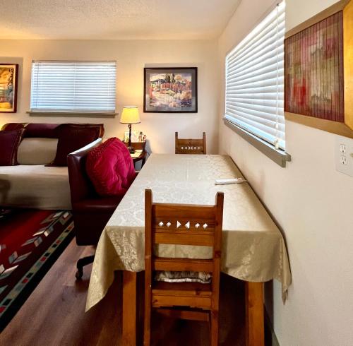 a living room with a table and a chair and a couch at Downtown Historic East-Side Coyote House 2B 2BA in Santa Fe