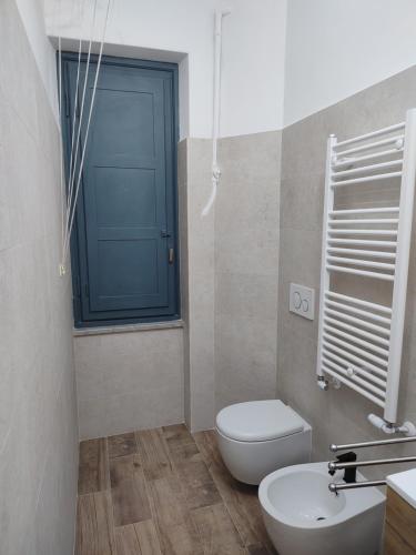 a bathroom with a white toilet and a blue door at Sweet Holiday in Rome