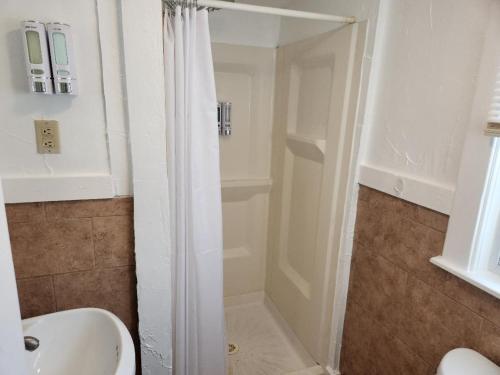a bathroom with a shower and a sink at Jonathan Edwards Motel in Dennis Port