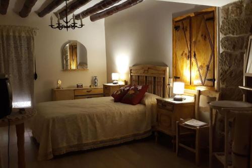 1 dormitorio con 1 cama, 2 mesas y espejo en One bedroom chalet with shared pool terrace and wifi at Sieso de Huesca, en Sieso de Huesca